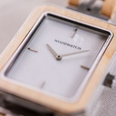 The Elegance Gleam Shade is crafted from maple wood and stainless steel, featuring a mother-of-pearl white dial and silver metal details.