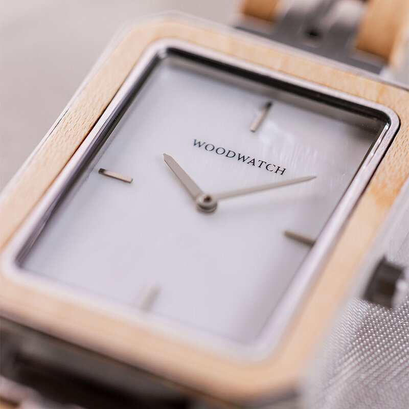 The Elegance Gleam Shade is crafted from maple wood and stainless steel, featuring a mother-of-pearl white dial and silver metal details.