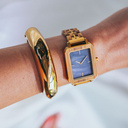 The Elegance Blue Pearl is crafted from olive wood and stainless steel, featuring a blue mother-of-pearl dial with brushed gold metal details.