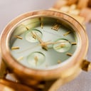 The Radiance Emerald Elegance is crafted from olive wood and stainless steel brushed gold, featuring a green dial and brushed gold metal details.
