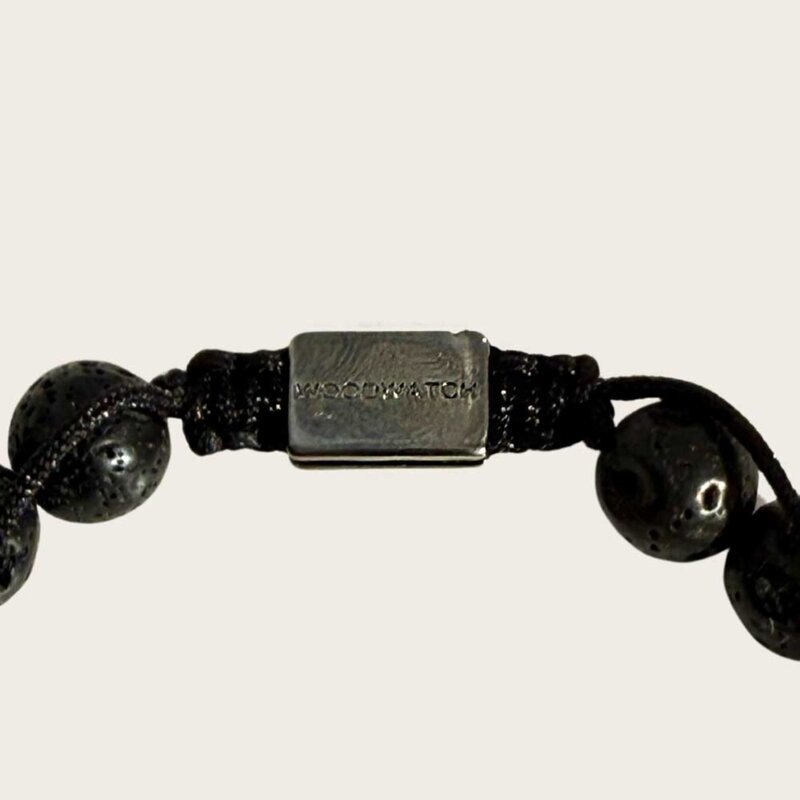 Made with rosewood beads, volcanic beads, dark green natural stone beads, and a matte black brass closure. Adjustable, with 8mm beads to fit most wrist sizes.