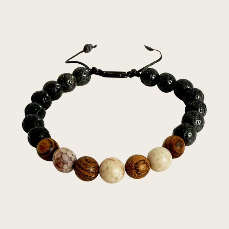 Made with rosewood beads, volcanic beads, dark green natural stone beads, and a matte black brass closure. Adjustable, with 8mm beads to fit most wrist sizes.