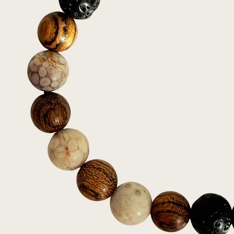 Made with rosewood beads, volcanic beads, dark green natural stone beads, and a matte black brass closure. Adjustable, with 8mm beads to fit most wrist sizes.