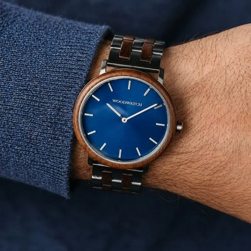 Un rinnovato design minimal con un look senza tempo, per adattarsi ad ogni occasione. Caratterizzato da una sottile cassa in acciaio, quadrante blu e lunetta in legno di noce. Viene fornito con un cinturino nuovo, progettato da zero per abbinarsi perfetta