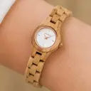 Het Blossom horloge uit de FLORA Collectie bestaat uit zacht olijfhout dat met de hand tot een slank ontwerp is vervaardigd. De wijzerplaat is gemaakt van een geborsteld crèmekleurige wijzerplaat van roestvrij staal dat licht glimt in de zon. Ook heeft de