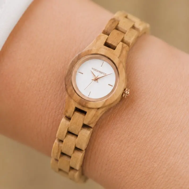 Het Blossom horloge uit de FLORA Collectie bestaat uit zacht olijfhout dat met de hand tot een slank ontwerp is vervaardigd. De wijzerplaat is gemaakt van een geborsteld crèmekleurige wijzerplaat van roestvrij staal dat licht glimt in de zon. Ook heeft de