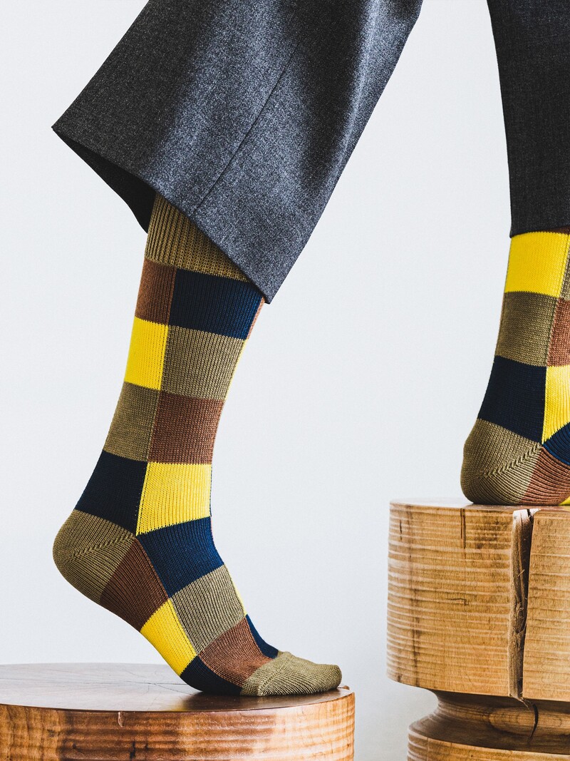 Kontrastierende Patchwork-Socken in der Mitte der Wade