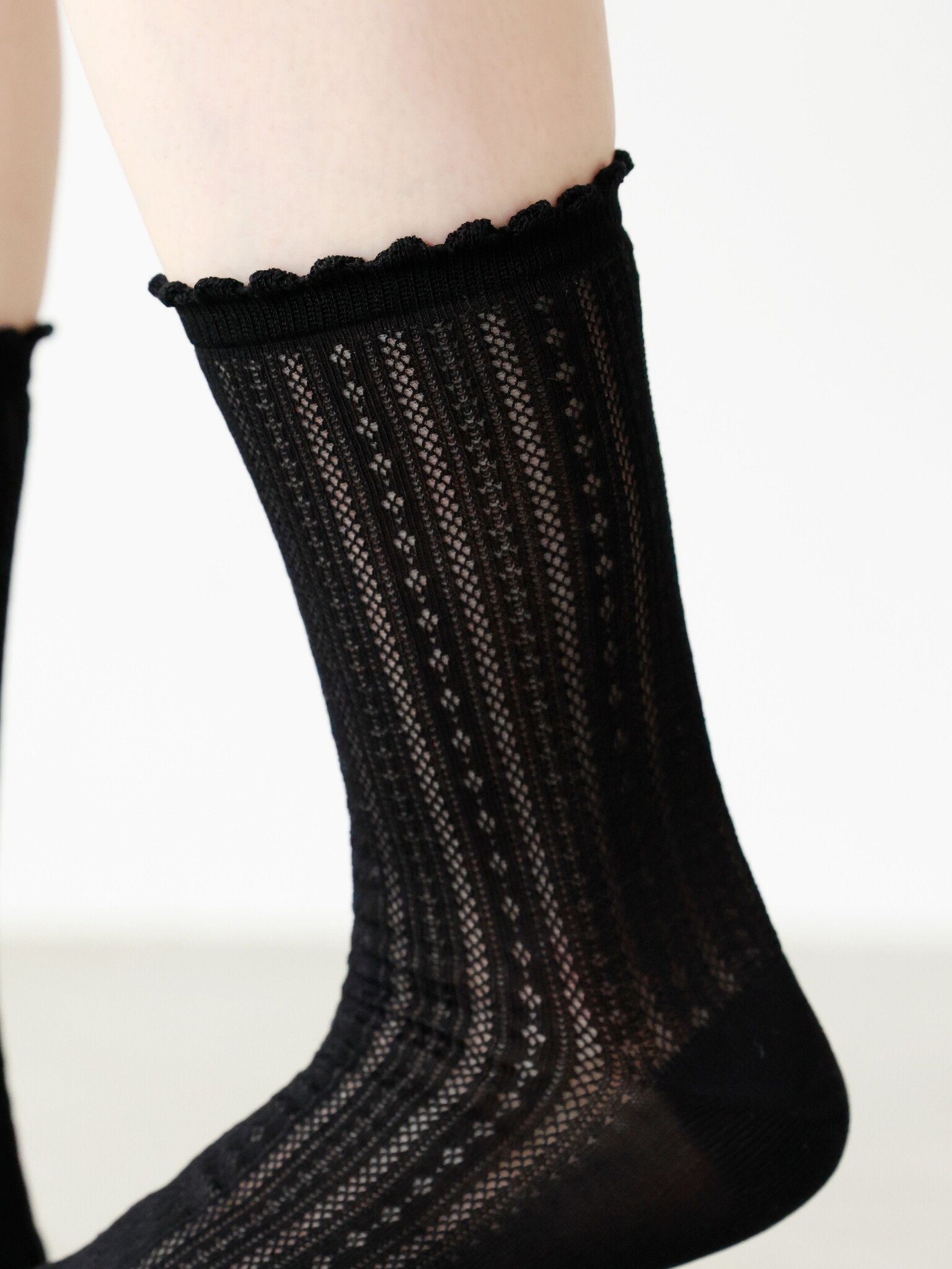 Meias até o joelho com padrão de renda e acabamento picot