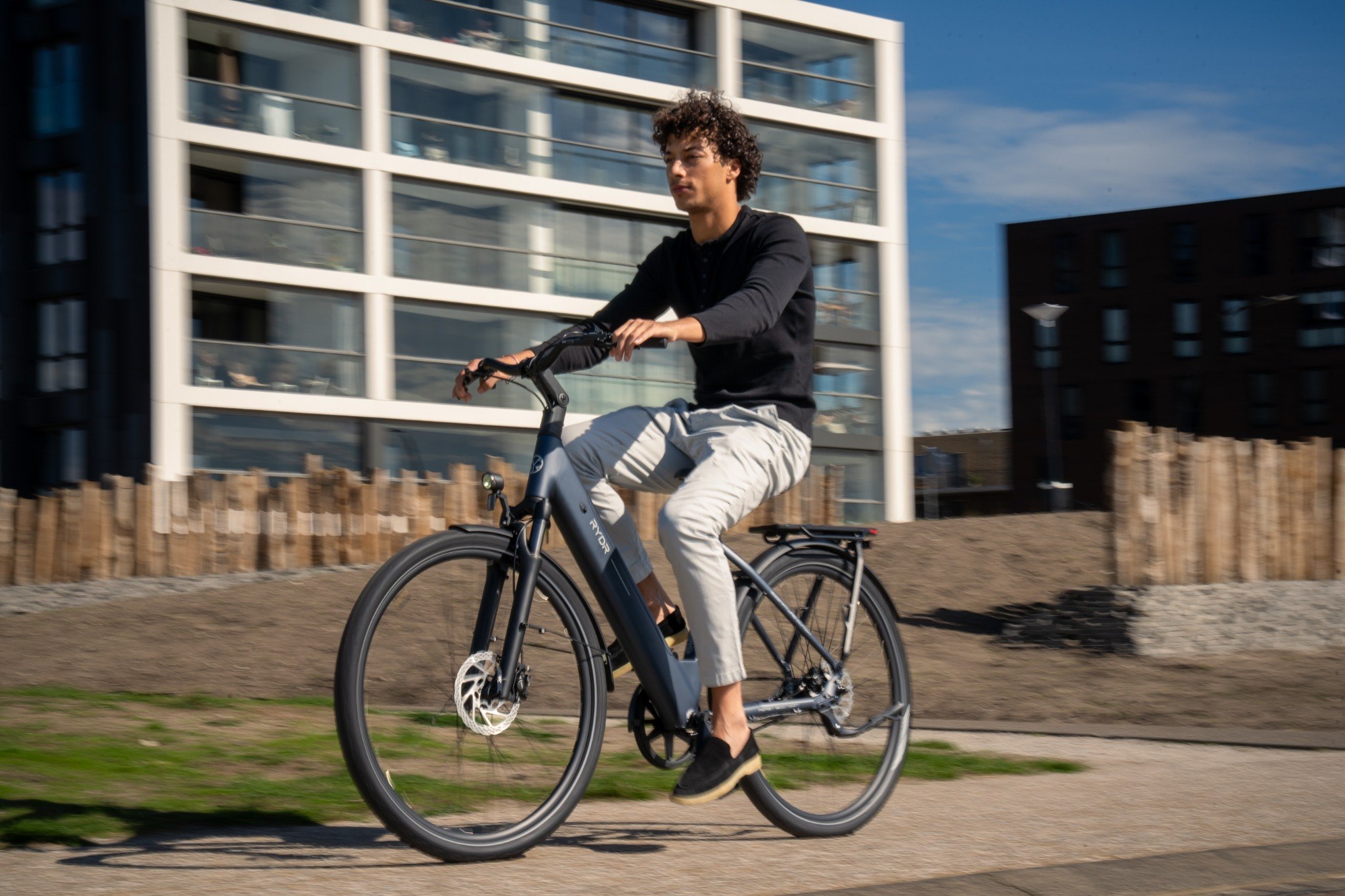 RYDR Core in donkerblauw bij een stadsbrug