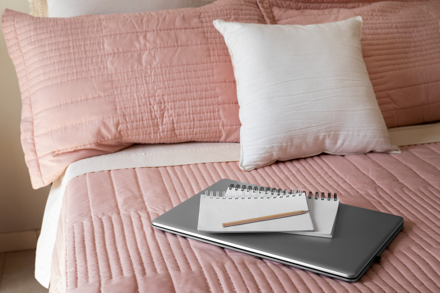 Roze kussenslopen en deken op een bed