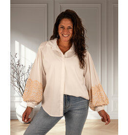 Witte blouse geborduurde mouw