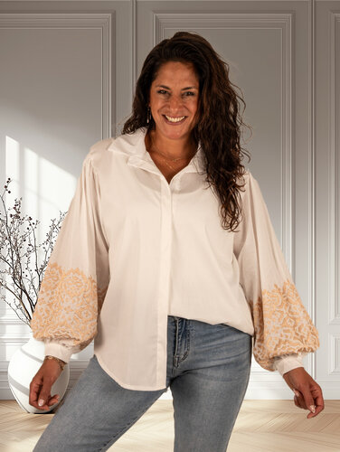Witte blouse geborduurde mouw