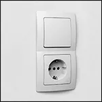 Kleine afbeelding van een witte HK05 schakelaar en stopcontact-combinatie op een witte wand