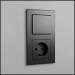 Kleine afbeelding van een Kopp HK07 PURE schakelaar en stopcontact-combinatie in de kleur antraciet op een grijze muur