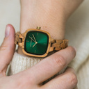 تتميز ساعة "آيفي" من مجموعة "سيتي" بتصميمها المربع ومقاسها الذي يبلغ 30 ملم ومينائها الأخضر ذي التفاصيل الذهبية اللون، إلى جانب حزامها المصنوع يدوياً بمهارة فائقة من خشب الزيتون الطبيعي ليصبح بذلك أحدث حزام صغير الحجم من WoodWatch.