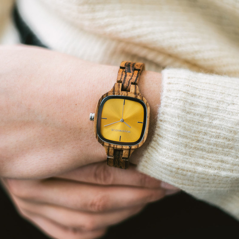 تتميز ساعة "لومن" من مجموعة "سيتي" بتصميمها المربع ومقاسها الذي يبلغ 30 ملم ومينائها الأصفر وحزامها المصنوع يدوياً بمهارة فائقة من خشب الزرد الطبيعي ليصبح بذلك أحدث حزام صغير الحجم من WoodWatch.