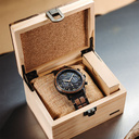 ساعة Craftmaster السوداء مصنوعة من خشب الجوز والفولاذ المقاوم للصدأ 304. تتميز بقرص أسود مع تفاصيل معدنية ذهبية.