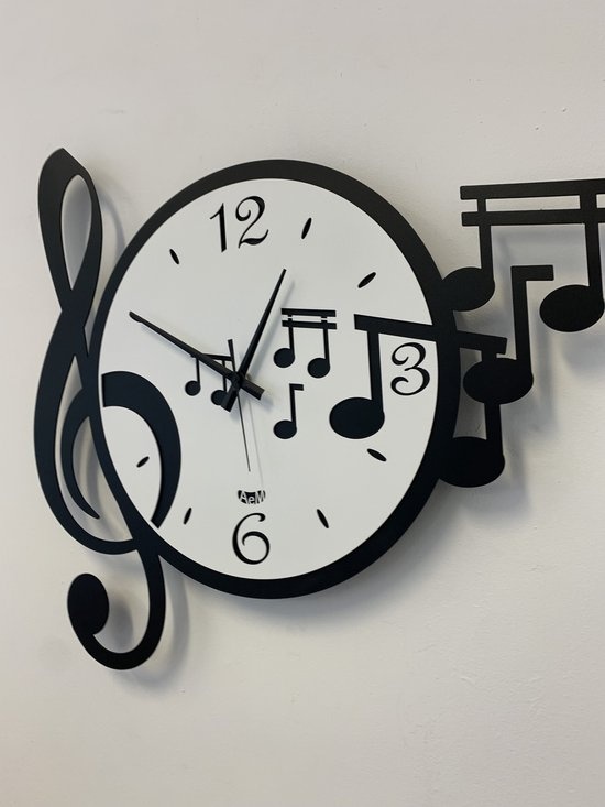 Wandklok versierd met een sleutel en vijf muzieknoten. Dynamisch en vrolijk design. Verkrijgbaar in twee kleurencombinaties.  Afmeting: 50 × 47  Materiaal: Metaal