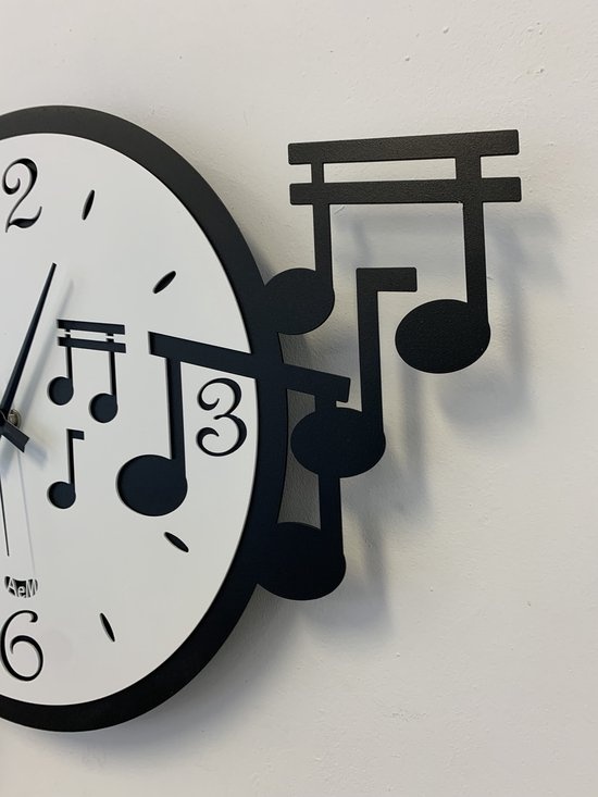 Wandklok versierd met een sleutel en vijf muzieknoten. Dynamisch en vrolijk design. Verkrijgbaar in twee kleurencombinaties.  Afmeting: 50 × 47  Materiaal: Metaal