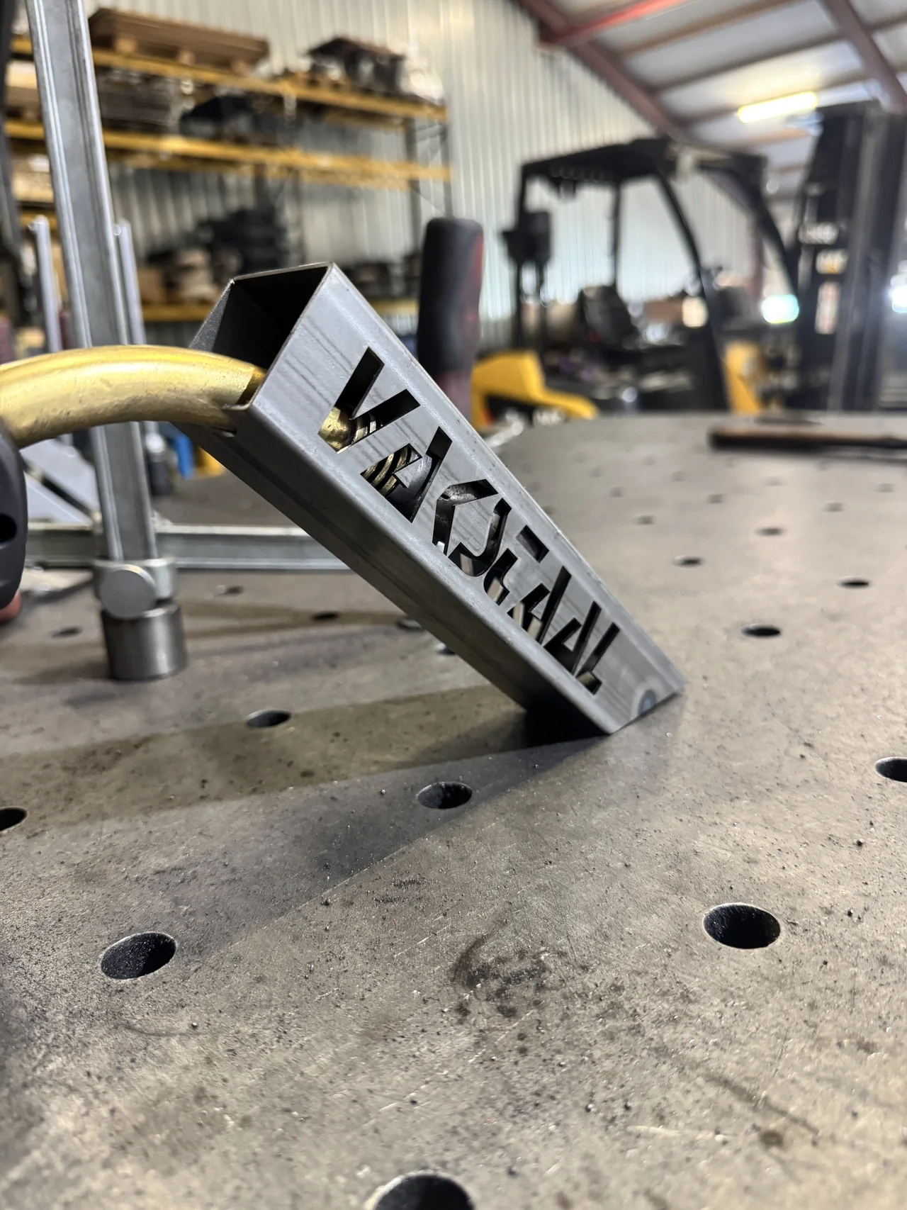 Stalen koker met de naam Vakstaal als lasergesneden uitsparing op een werktafel
