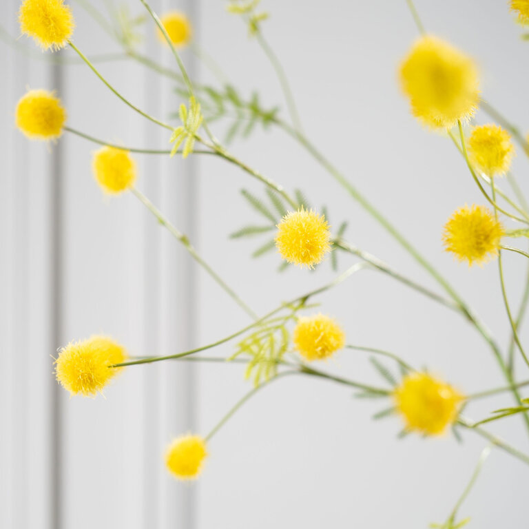 Kunststeel Mimosa met gele bloemen en groene bladeren is een kunststeel met een natuurgetrouwe uitstraling en een lengte van 106 cm.