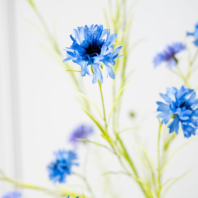 Kunststeel Korenbloem met blauwe zijden bloemen en groene bladeren is een kunststeel met een natuurgetrouwe uitstraling en een lengte van 92 cm.