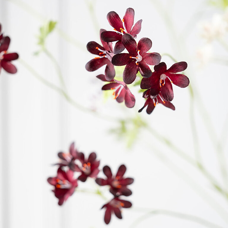 Kunststeel Geranium met donkerrode zijden bloemen en groene bladeren is een kunststeel met een natuurgetrouwe uitstraling en een lengte van 94 cm.