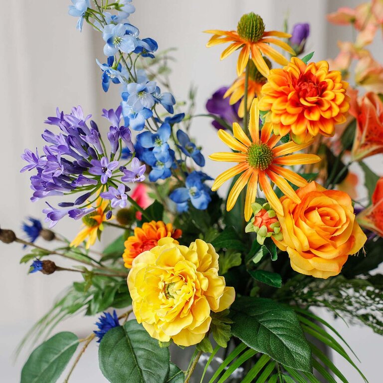 Zijden bloemen boeket Lucy Lou is een klein en kleurrijk boeket van kunstbloemen in gele, blauwe, roze, paarse en oranje tinten.