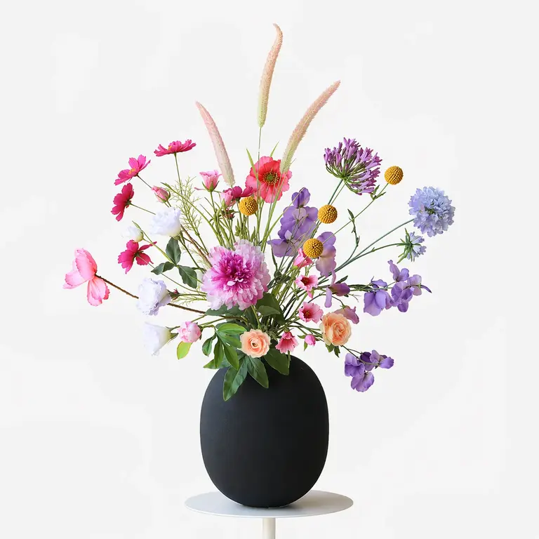 Zijden bloemen boeket Inara Field is een luchtig en organisch veldboeket van kunstbloemen in roze, paarse, gele en blauwe tinten.