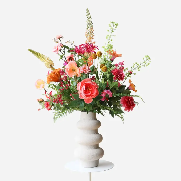 Zijden bloemen boeket Niva Solis is een vol en warm boeket van kunstbloemen in oranje, roze, gele en paarse tinten.