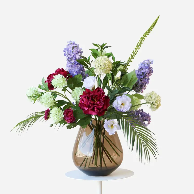 Zijden bloemen boeket Mabel Everleigh is een klein en natuurlijk boeket van kunstbloemen in paarse, witte en groene tinten.