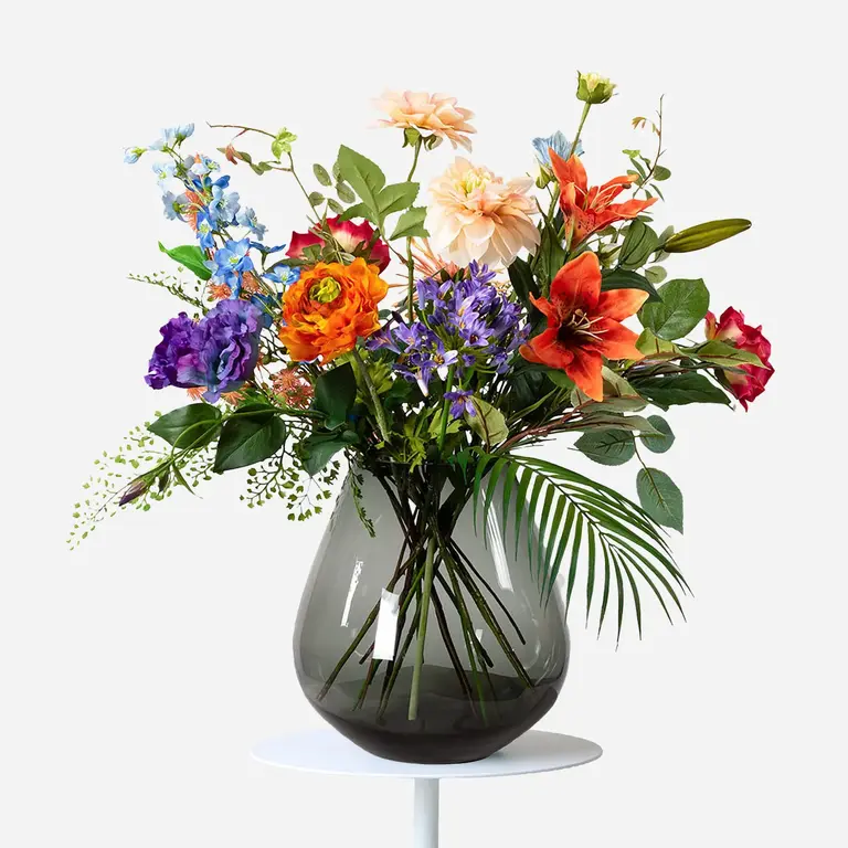Zijden bloemen boeket Dixie Dawn is een klein en kleurrijk boeket van kunstbloemen in rode, oranje, roze, paarse en blauwe tinten.