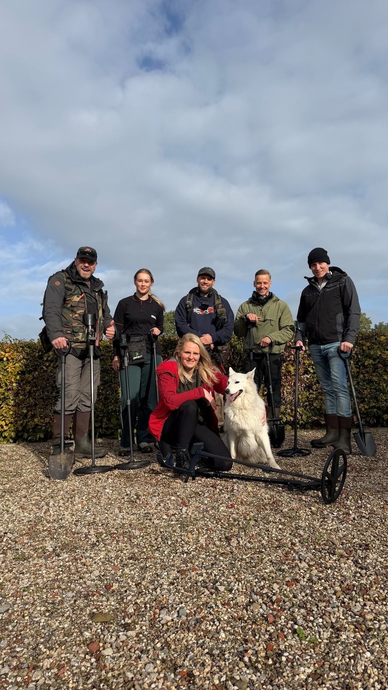Zoekgroep met metaaldetectors en schoppen voor de zoekdag met de XP ICON X: Erwin, Nina, Feike, Willem en Mathijs staand, Elise geknield naast hond Sky