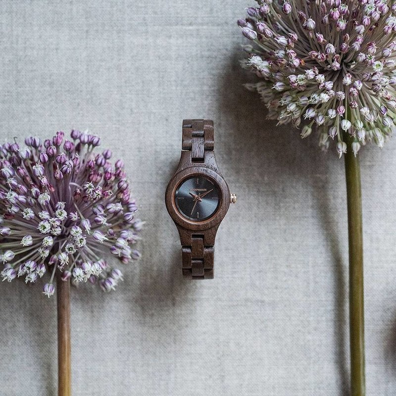 The Viola watch from the FLORA Collection owes its name to be as unique as the sight of a black moon viola flower. Natural walnut wood has been hand-crafted to its finest slenderness. The Viola dial is made of a brushed black stainless-steel that has a sh