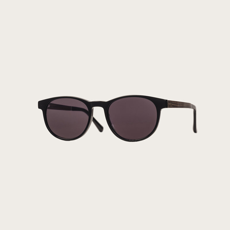 The ELLIPSE All Black features a characteristic rounded black frame with black lenses. Composed of durable Italian Mazzucchelli bio-acetate with hand-finished natural rosewood temples and black acetate tips. Bio-acetate is made from cotton and organic res