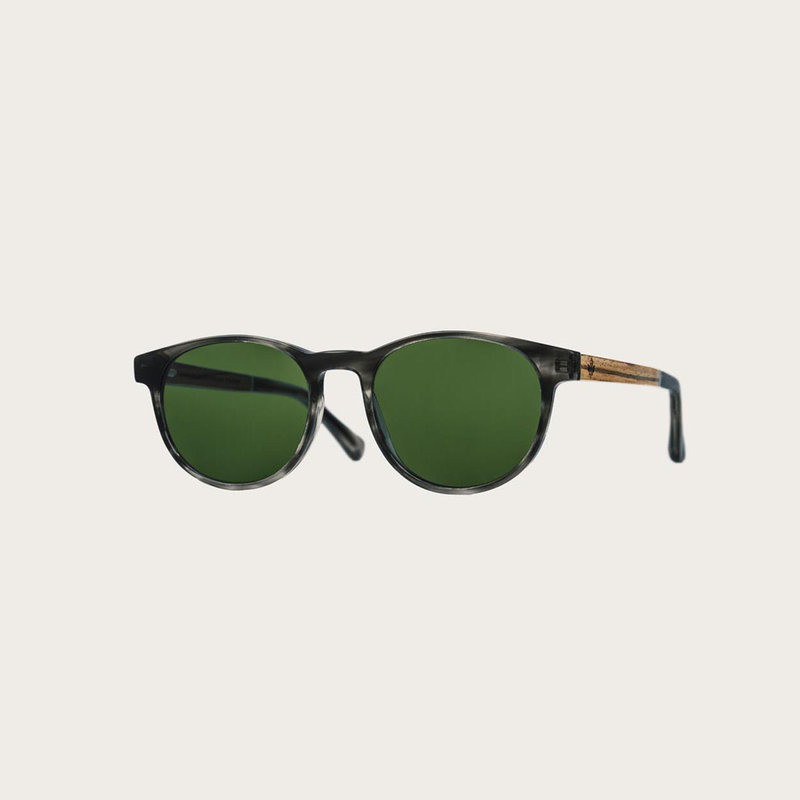 The ELLIPSE Heritage Camo features a characteristic rounded grey tortoise frame with green camo lenses. Composed of durable Italian Mazzucchelli bio-acetate with hand-finished natural zebrawood temples and tortoise acetate tips. Bio-acetate is made from c