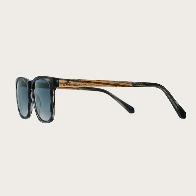 The BROOKLYN Heritage Gradient Blue features a squared grey tortoise frame with gradient blue lenses. Composed of durable Italian Mazzucchelli bio-acetate with hand-finished natural zebrawood temples and tortoise acetate tips. Bio-acetate is made from cot