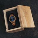 The AURORA Collection breaths the fresh air of Scandinavian nature and the astonishing views of the sky. This light weighing watch is made of kosso wood, accompanied by a blue stainless-steel dial with golden details.<br />
The watch is available with a wooden