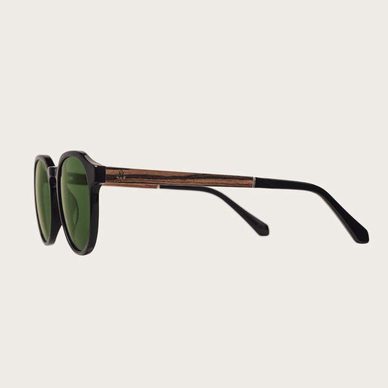 The REVELER Black Camo features a sleek geometric black frame with green camo lenses. Composed of durable Italian Mazzucchelli bio-acetate with hand-finished natural rosewood temples and black acetate tips. Bio-acetate is made from cotton and organic resi