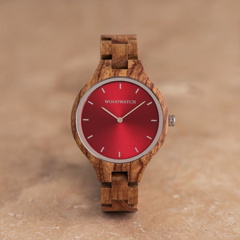 The AURORA Collection breaths the fresh air of Scandinavian nature and the astonishing views of the sky. This light weighing watch is made of kosso wood, accompanied by a red stainless-steel dial. The watch is available with a wooden strap or a leather st