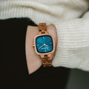 The CITY Atomic features a 30mm square case with a blue dial and golden details. The watch band consists of natural Mahogany wood that has been hand-finished to perfection and to create our latest small-band design.