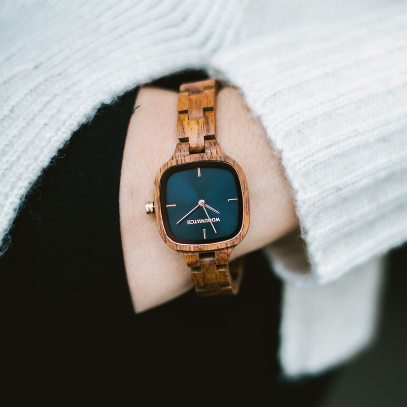 The CITY Stellar features a 30mm square case with a blue dial with rose gold details. The watch band consists of natural kosso wood that has been hand-finished to perfection and to create our latest small-band design.