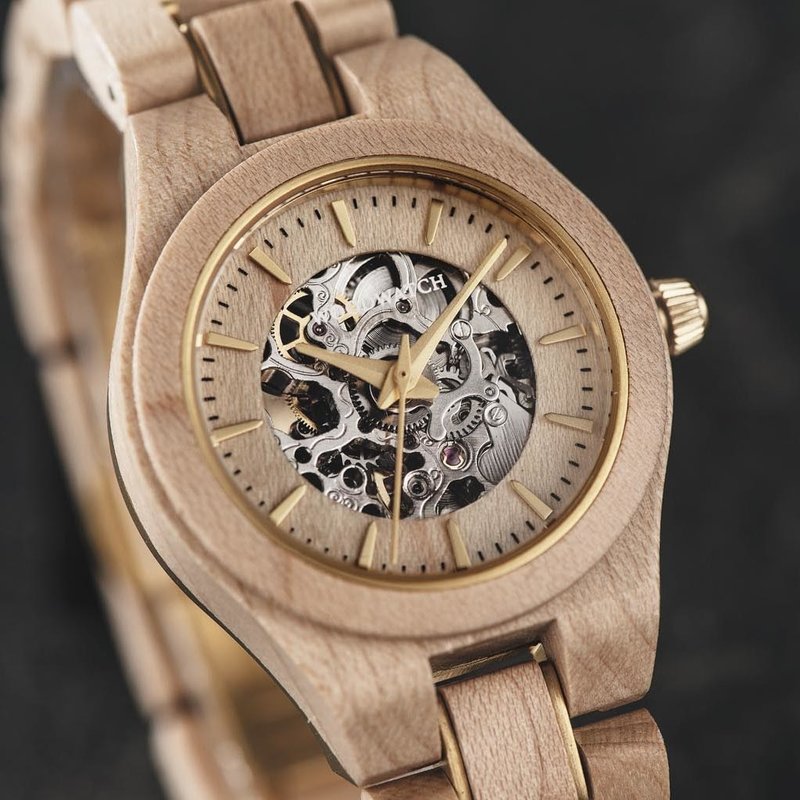 The AUTOMATIC Nomad features a self-winding automatic mechanical movement with 36 hours power reserve. A distinctive optical experience is created through the 33mm case with a gold bezel and partial wooden dial with an open heart, revealing the complexity