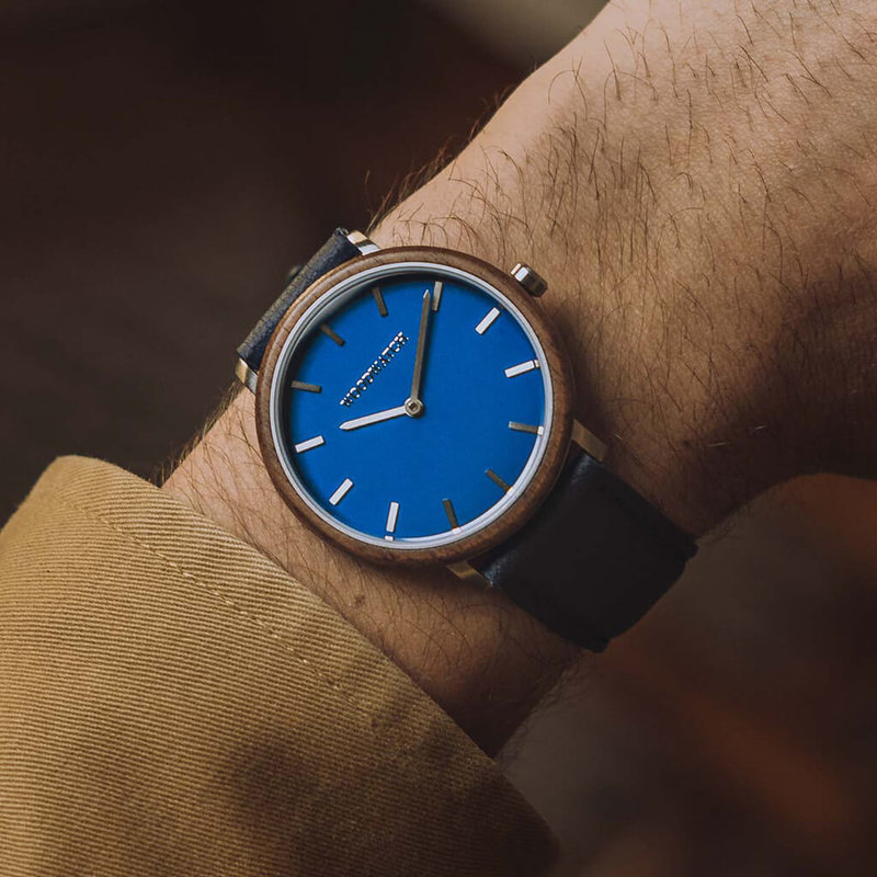 A renewed MINIMAL design with a timeless look that matches any occasion. Featuring a thin, steel case, and walnut bezel and blue dial. Comes with a new watch strap, designed from the ground up to perfectly match the minimal watch case in style and materia