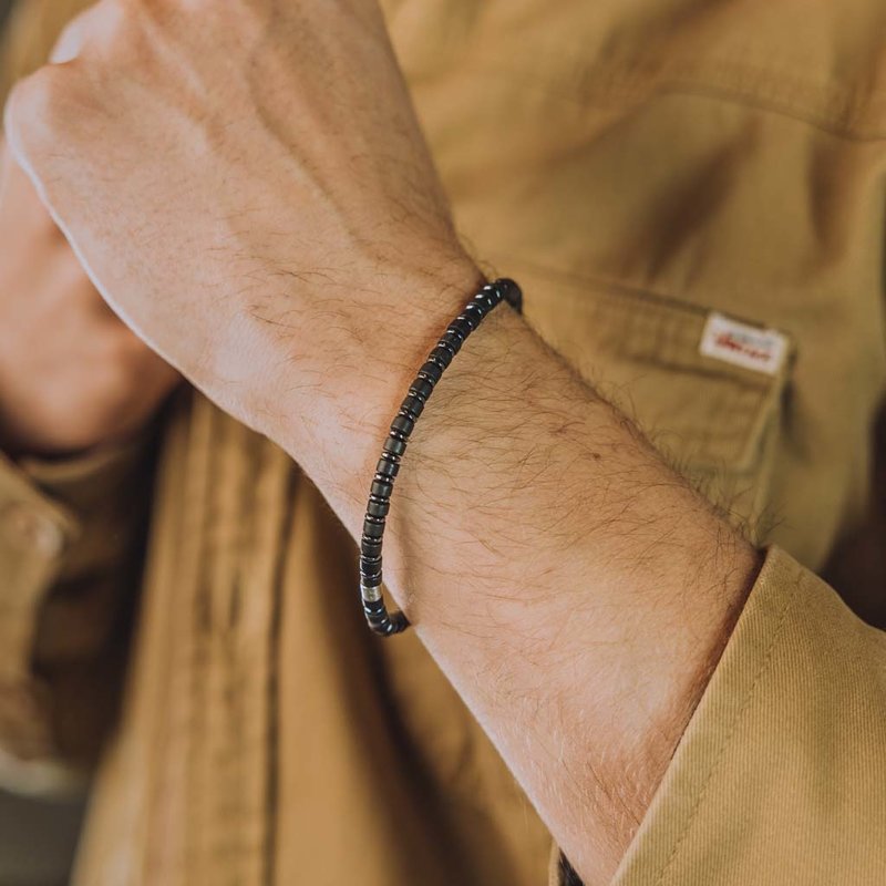 Handmade natural stone bracelet from black agate. Features 4mm sliced beads and a stainless steel accent. Made with a quality stretch cord to easily put it on and take it off.