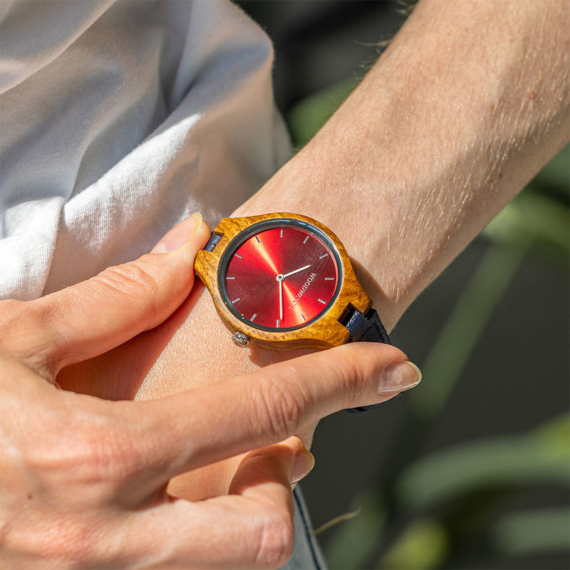 The AURORA Collection breaths the fresh air of Scandinavian nature and the astonishing views of the sky. This light weighing watch is made of kosso wood, accompanied by a red stainless-steel dial. Comes with a cactus leather strap in matching navy blue, e