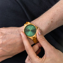 The AURORA Collection breaths the fresh air of Scandinavian nature and the astonishing views of the sky. This light weighing watch is made of olive wood, accompanied by a green stainless-steel dial with golden details.<br />
Comes with a cactus leather strap in