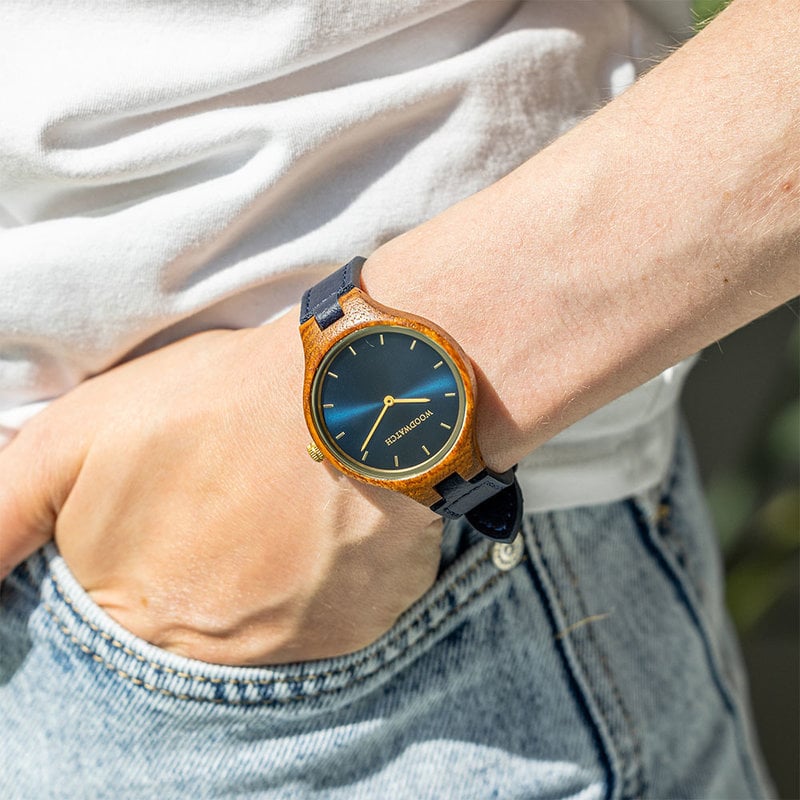The AURORA Collection breaths the fresh air of Scandinavian nature and the astonishing views of the sky. This light weighing watch is made of kosso wood, accompanied by a blue stainless-steel dial with golden details.<br />
Comes with a cactus leather strap in