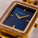 The Elegance Midnight Shade is crafted from walnut wood and stainless steel, featuring a navy blue dial with brushed gold metal details.