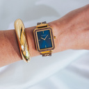 The Elegance Midnight Shade is crafted from walnut wood and stainless steel, featuring a navy blue dial with brushed gold metal details.